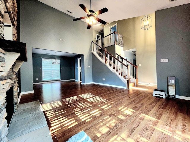 3108 Leicester Dr, Matthews, NC 28104 - unfurnished living room with a fireplace, stairway, a towering ceiling, wood finished floors, and ceiling fan