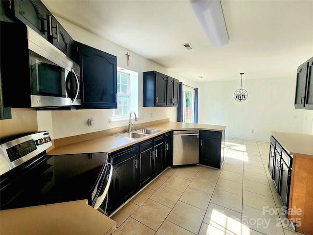 3108 Leicester Dr, Matthews, NC 28104 - kitchen with appliances with stainless steel finishes, a peninsula, light tile patterned floors, dark cabinets, and light countertops