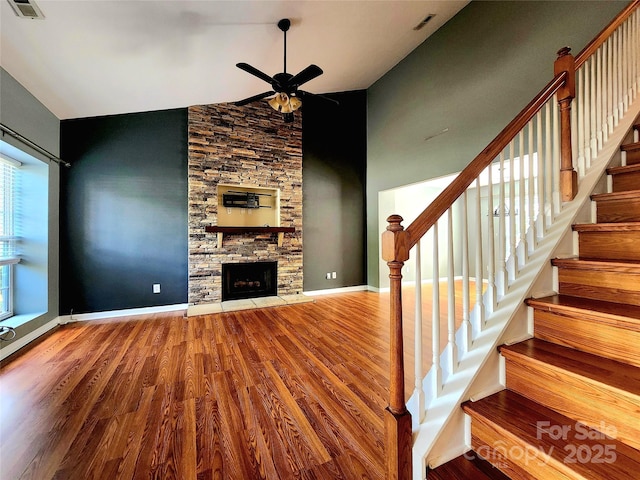 3108 Leicester Dr, Matthews, NC 28104 - unfurnished living room with wood finished floors, ceiling fan, stairs, a fireplace, and high vaulted ceiling