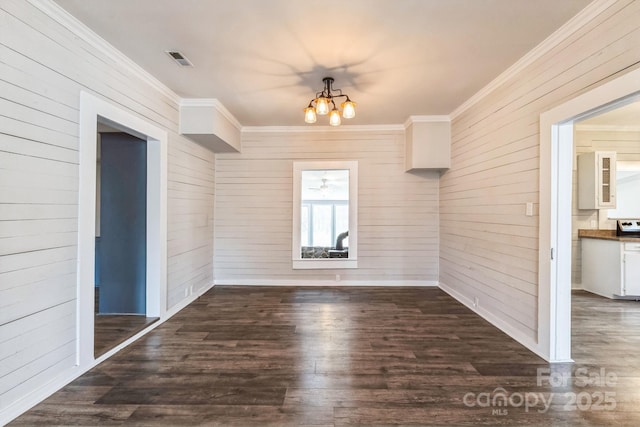 3607 Austin Rd, Monroe, NC 28112 - unfurnished dining area with crown molding, wooden walls, dark wood-style floors, and a chandelier