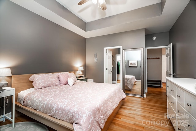 2124 Congress Ct, Kannapolis, NC 28083 - bedroom with light wood-type flooring, a raised ceiling, and a ceiling fan