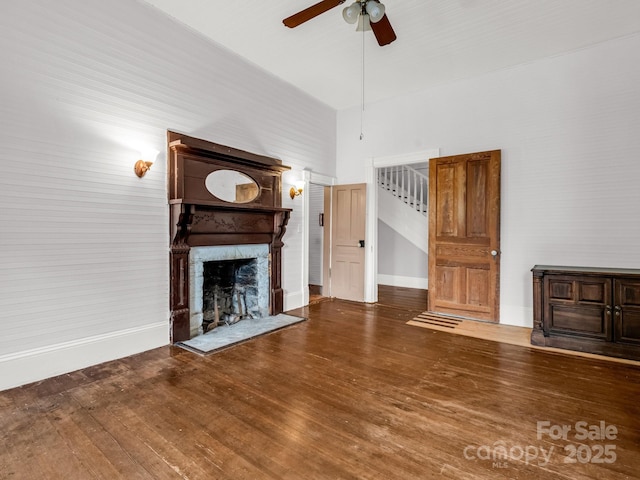 1111 Bills Creek Rd, Lake Lure, NC 28746 - unfurnished living room with ceiling fan, a large fireplace, wood finished floors, a towering ceiling, and stairway