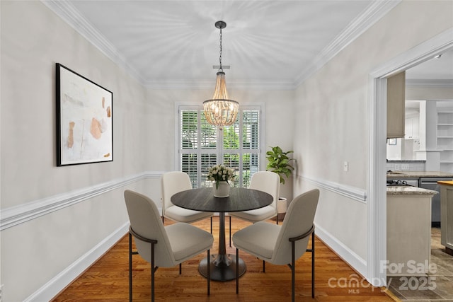 3535 Selwyn Farms Ln, Charlotte, NC 28209 - dining space with a chandelier, wood finished floors, and crown molding