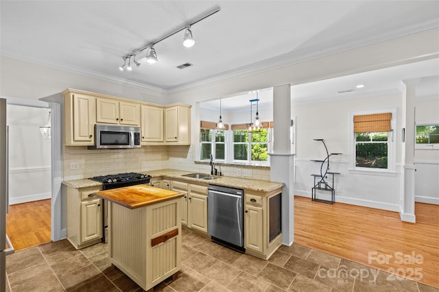 3535 Selwyn Farms Ln, Charlotte, NC 28209 - kitchen with stainless steel appliances, cream cabinets, wooden counters, ornamental molding, and a center island