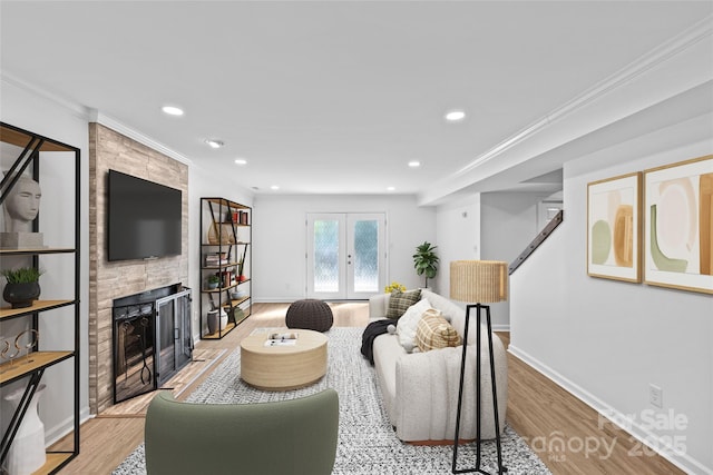 11401 Lone Star Cir, Charlotte, NC 28226 - living room with light wood-style floors, a fireplace, recessed lighting, ornamental molding, and french doors