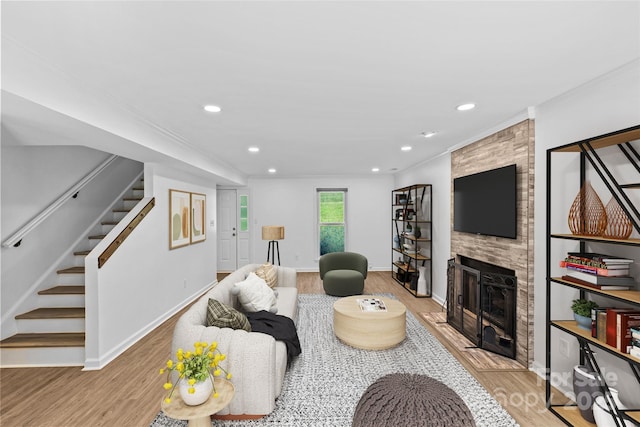 11401 Lone Star Cir, Charlotte, NC 28226 - living room featuring stairs, a fireplace, wood finished floors, recessed lighting, and ornamental molding