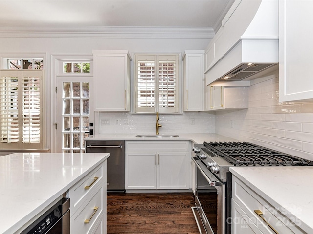 344 S Laurel Ave, Charlotte, NC 28207 - kitchen with stainless steel appliances, custom range hood, light countertops, crown molding, and white cabinetry
