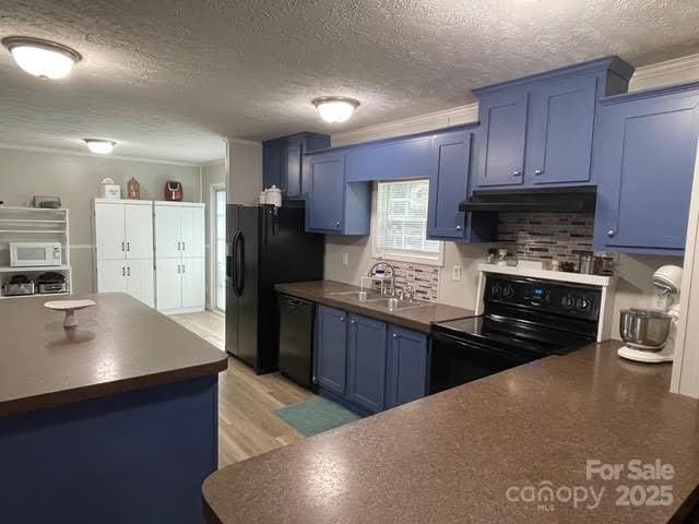 25 Mountain View Rdg, Fairview, NC 28730 - kitchen with black appliances, blue cabinets, under cabinet range hood, dark countertops, and crown molding