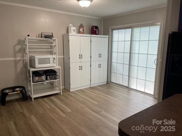 25 Mountain View Rdg, Fairview, NC 28730 - bedroom featuring wood finished floors, ornamental molding, and black fridge