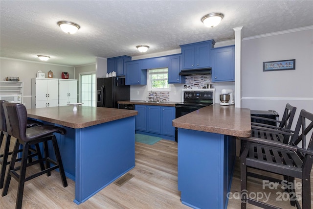 25 Mountain View Rdg, Fairview, NC 28730 - kitchen featuring black appliances, blue cabinets, dark countertops, a kitchen bar, and a textured ceiling