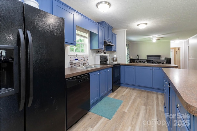 25 Mountain View Rdg, Fairview, NC 28730 - kitchen featuring black appliances, blue cabinets, under cabinet range hood, light wood-type flooring, and a textured ceiling