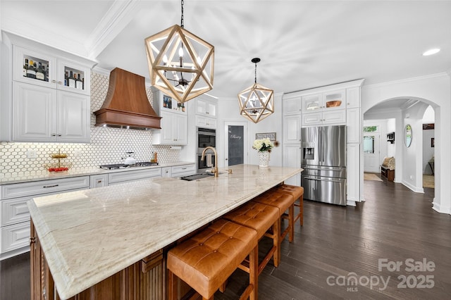 3981 Spinnaker Pl, Denver, NC 28037 - kitchen with appliances with stainless steel finishes, custom range hood, arched walkways, crown molding, and decorative backsplash