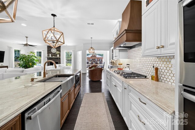 3981 Spinnaker Pl, Denver, NC 28037 - kitchen featuring premium range hood, stainless steel appliances, open floor plan, decorative backsplash, and light stone counters