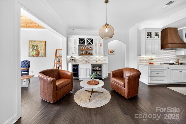 3981 Spinnaker Pl, Denver, NC 28037 - living room with a dry bar, arched walkways, crown molding, beverage cooler, and dark wood-type flooring