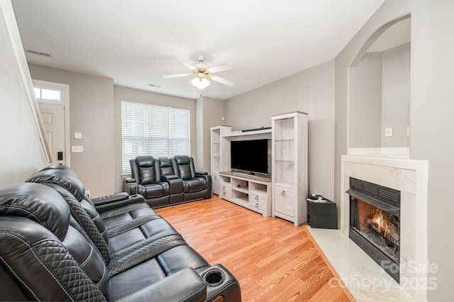 7518 Silver Arrow Dr, Charlotte, NC 28273 - living room featuring a high end fireplace, a ceiling fan, light wood finished floors, and arched walkways