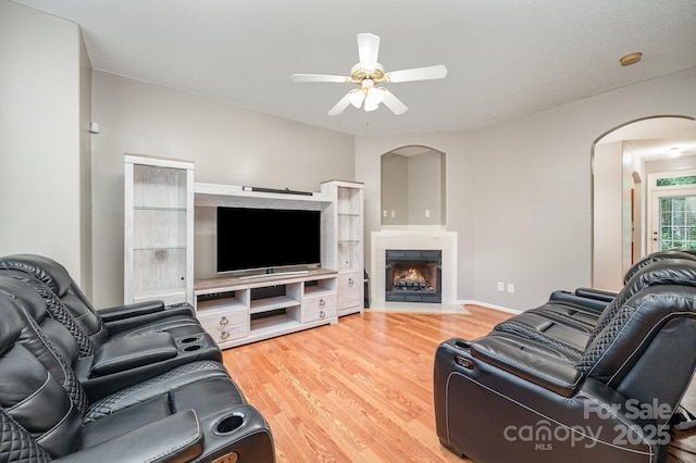 7518 Silver Arrow Dr, Charlotte, NC 28273 - living room featuring arched walkways, a ceiling fan, wood finished floors, and a fireplace with flush hearth