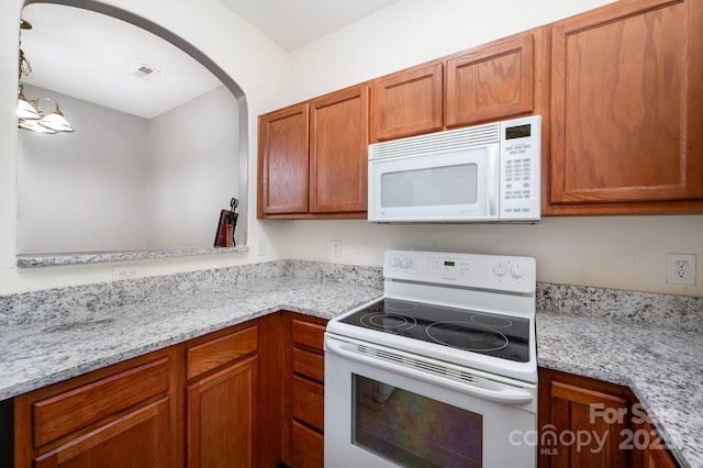 7518 Silver Arrow Dr, Charlotte, NC 28273 - kitchen featuring white appliances, arched walkways, and brown cabinets