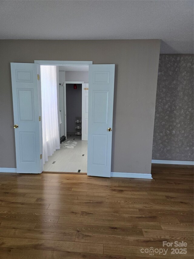 3 Hidden Sands Ct, Columbia, SC 29229 - empty room with wood finished floors, wallpapered walls, and a textured ceiling