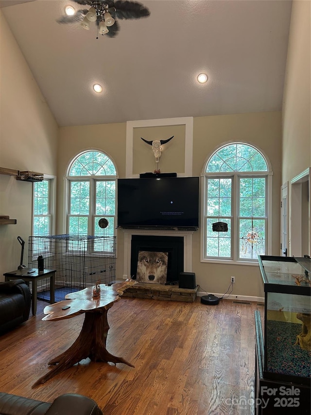 207 Wagon Ln, Rutherfordton, NC 28139 - living area with ceiling fan, high vaulted ceiling, wood finished floors, a fireplace with raised hearth, and recessed lighting