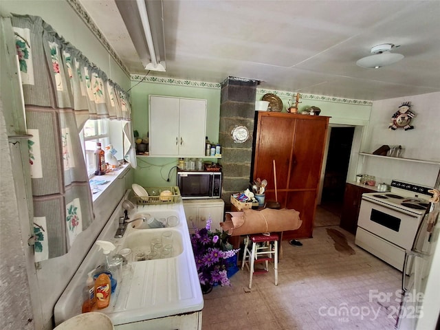 2087 Henry Rd, Sylva, NC 28779 - kitchen with electric range, light floors, and white cabinetry