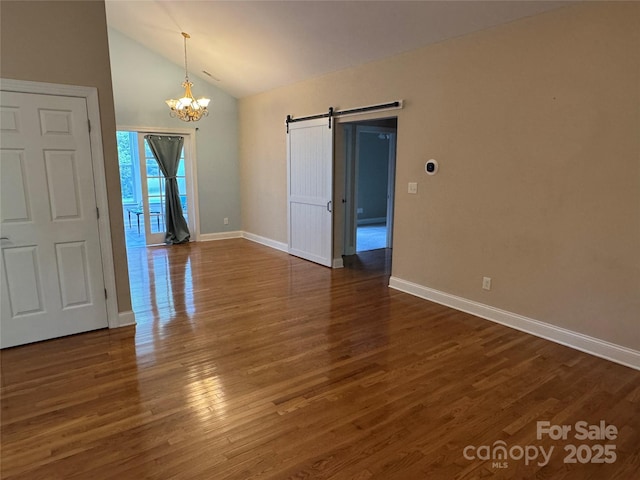 13221 Brandywine Ln, Midland, NC 28107 - empty room featuring a barn door, a chandelier, lofted ceiling, and wood finished floors