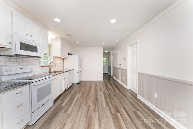 909 Lakeview St, Kannapolis, NC 28083 - kitchen featuring white appliances, light wood-style floors, white cabinetry, ornamental molding, and a wainscoted wall