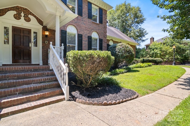 1134 Willow Oaks Trl, Matthews, NC 28104 - view of exterior entry with brick siding and a lawn