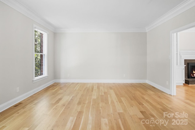 1134 Willow Oaks Trl, Matthews, NC 28104 - empty room with light wood-type flooring, ornamental molding, and a lit fireplace