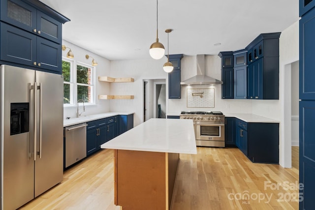 1134 Willow Oaks Trl, Matthews, NC 28104 - kitchen with high end appliances, wall chimney exhaust hood, blue cabinetry, and a kitchen island