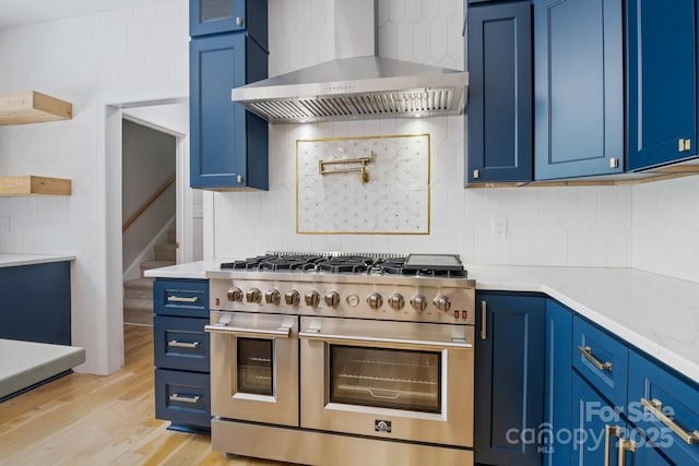 1134 Willow Oaks Trl, Matthews, NC 28104 - kitchen with range with two ovens, wall chimney exhaust hood, blue cabinetry, and tasteful backsplash