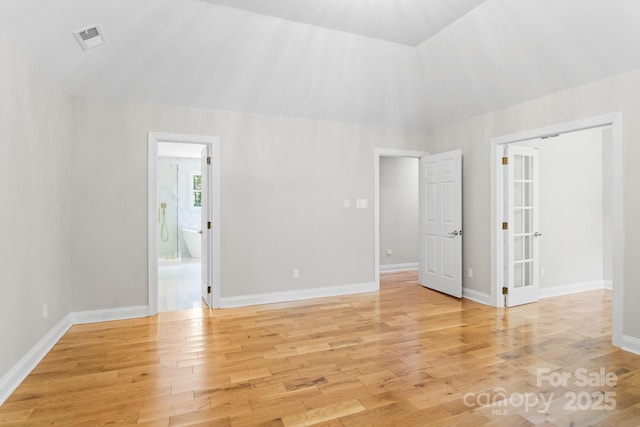 1134 Willow Oaks Trl, Matthews, NC 28104 - unfurnished bedroom featuring light wood-style floors, lofted ceiling, and connected bathroom