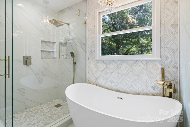 1134 Willow Oaks Trl, Matthews, NC 28104 - full bathroom featuring a chandelier, a marble finish shower, a freestanding bath, and tile walls