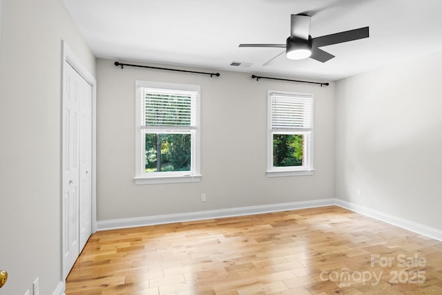 1134 Willow Oaks Trl, Matthews, NC 28104 - unfurnished bedroom with multiple windows, light wood-style floors, a closet, and ceiling fan
