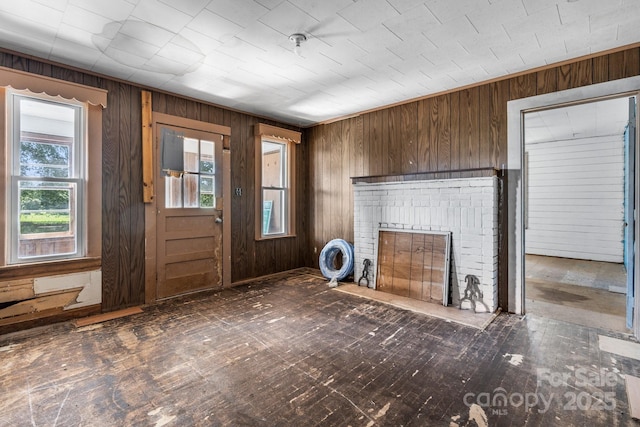 5560 Springs Rd, Conover, NC 28613 - unfurnished living room with wood walls, healthy amount of natural light, and a brick fireplace