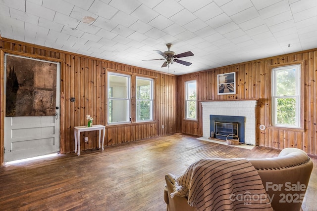 5560 Springs Rd, Conover, NC 28613 - living room with ceiling fan, wood walls, a fireplace, and hardwood / wood-style floors