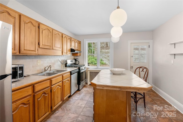 30 Caledonia Rd, Asheville, NC 28803 - kitchen featuring under cabinet range hood, tile counters, stainless steel appliances, decorative backsplash, and a breakfast bar