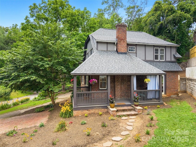 30 Caledonia Rd, Asheville, NC 28803 - view of front facade featuring covered porch, a shingled roof, a chimney, and brick siding