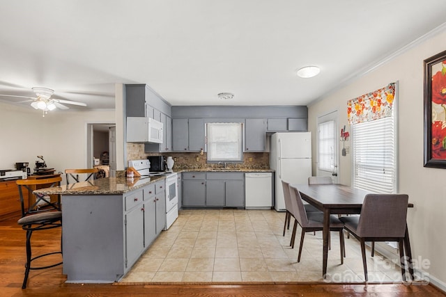 662 Willa Ct Unit 8, Chester, SC 29706 - kitchen with white appliances, gray cabinets, a peninsula, a breakfast bar, and tasteful backsplash