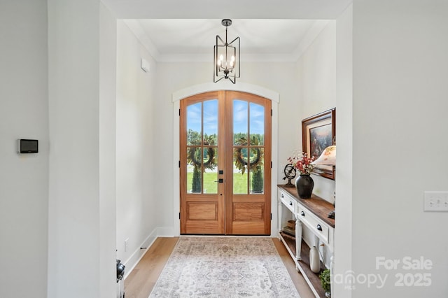 19 Berea Baptist Church Rd, Stanfield, NC 28163 - entrance foyer with light wood finished floors, a chandelier, arched walkways, french doors, and ornamental molding