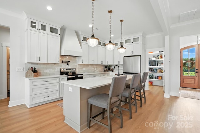 19 Berea Baptist Church Rd, Stanfield, NC 28163 - kitchen with stainless steel electric range, custom exhaust hood, freestanding refrigerator, light countertops, and light wood-style flooring