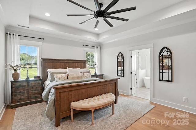 19 Berea Baptist Church Rd, Stanfield, NC 28163 - bedroom featuring a raised ceiling, light wood-style flooring, multiple windows, recessed lighting, and ensuite bathroom