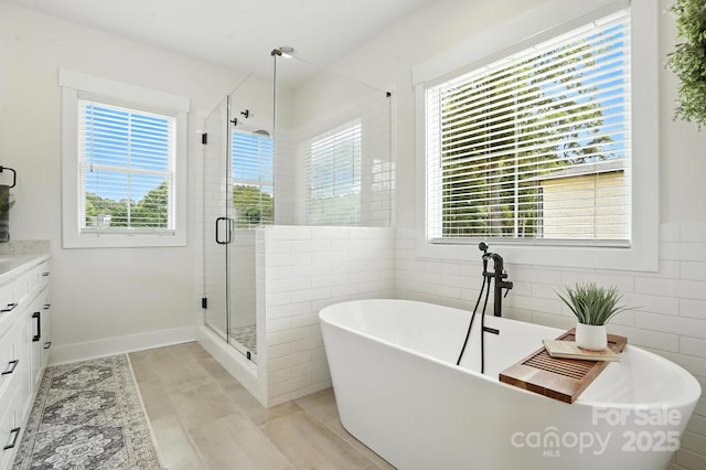 19 Berea Baptist Church Rd, Stanfield, NC 28163 - bathroom with vanity, healthy amount of natural light, a shower stall, a freestanding bath, and tile walls