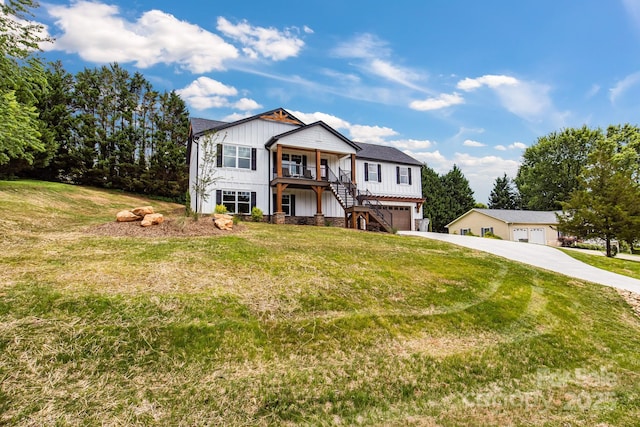 2205 Olde W Rd, Hudson, NC 28638 - view of front of house featuring stairway, board and batten siding, covered porch, an attached garage, and a front lawn