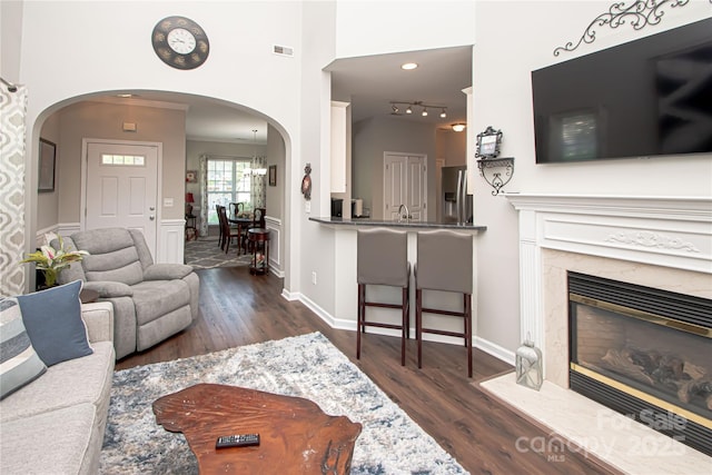 1304 Hammond Dr, Matthews, NC 28104 - living area featuring arched walkways, dark wood-style flooring, and a high end fireplace
