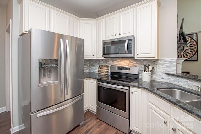 1304 Hammond Dr, Matthews, NC 28104 - kitchen with appliances with stainless steel finishes, dark wood-style floors, decorative backsplash, and dark stone counters