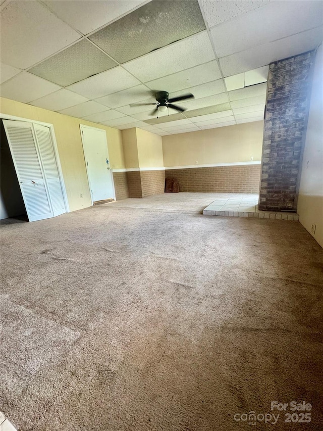 5367 Meadowlane Dr, Granite Falls, NC 28630 - spare room with a drop ceiling, brick wall, carpet floors, a wainscoted wall, and a ceiling fan