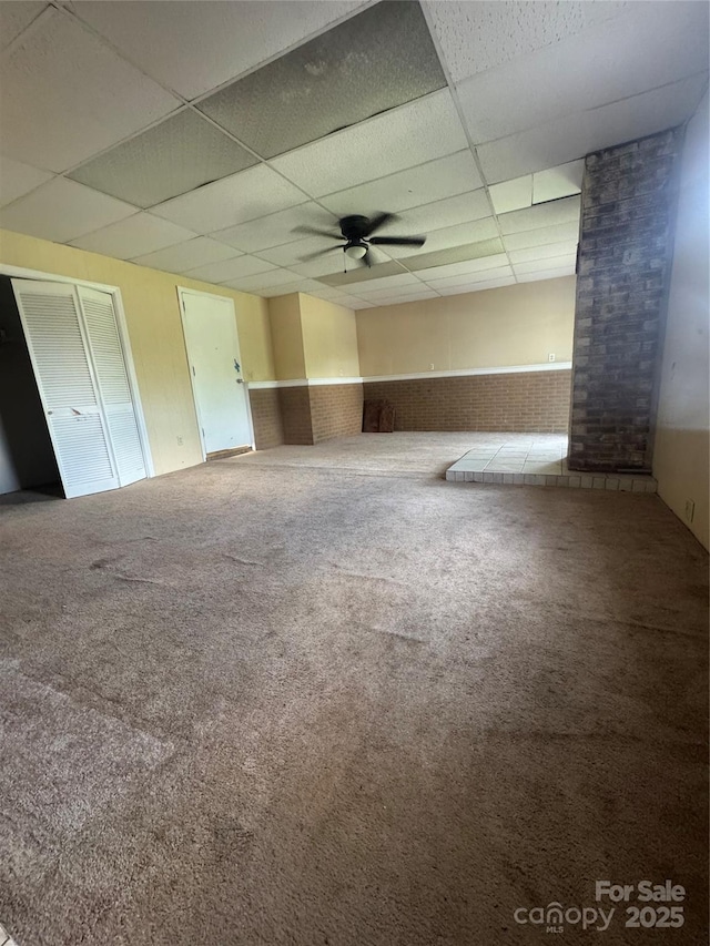 5367 Meadowlane Dr, Granite Falls, NC 28630 - carpeted spare room featuring a paneled ceiling, ceiling fan, wainscoting, and brick wall