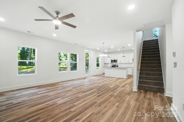 411 Patience Dr, Concord, NC 28025 - unfurnished living room with stairway, light wood-style floors, recessed lighting, and a ceiling fan