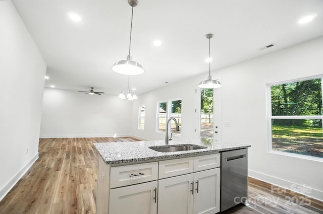 411 Patience Dr, Concord, NC 28025 - kitchen featuring stainless steel dishwasher, white cabinets, light wood-type flooring, light stone countertops, and a center island with sink