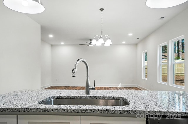 411 Patience Dr, Concord, NC 28025 - kitchen with wood finished floors, light stone counters, recessed lighting, a chandelier, and open floor plan